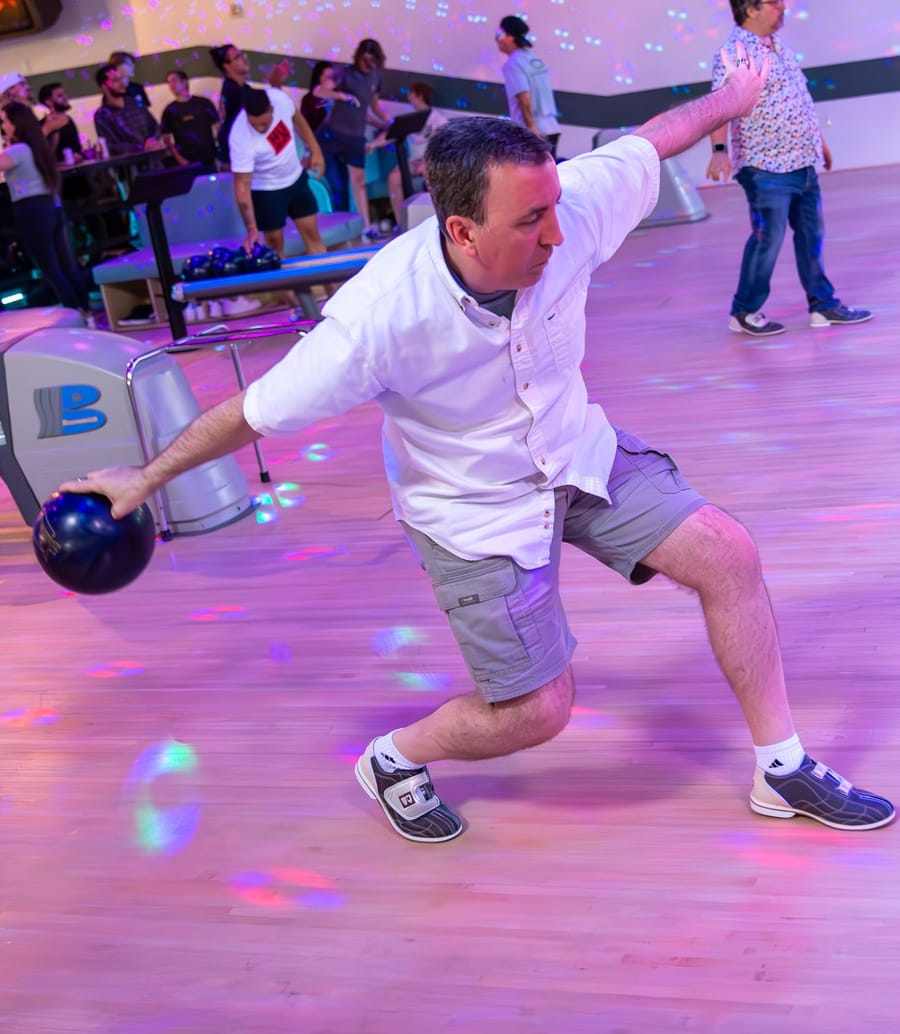 A Joybreak regular bowling under neon lights at a bowling night in Orlando