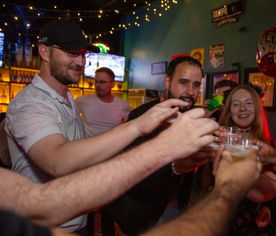 A group of friends raising a toast at a Joybreak social night in downtown Orlando