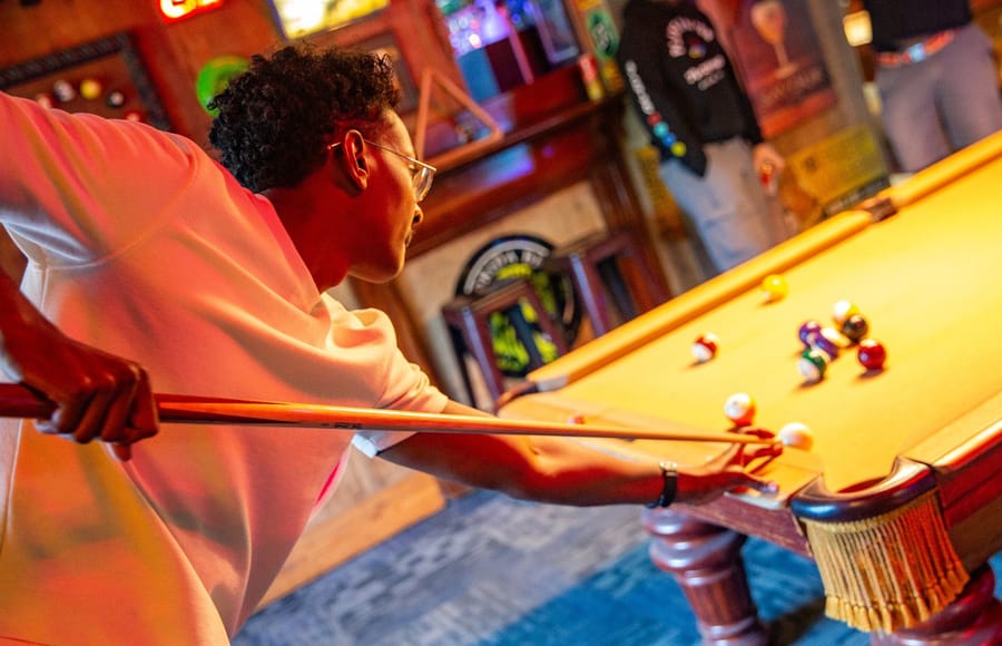 Someone lining up a pool shot at a Joybreak game night in Orlando